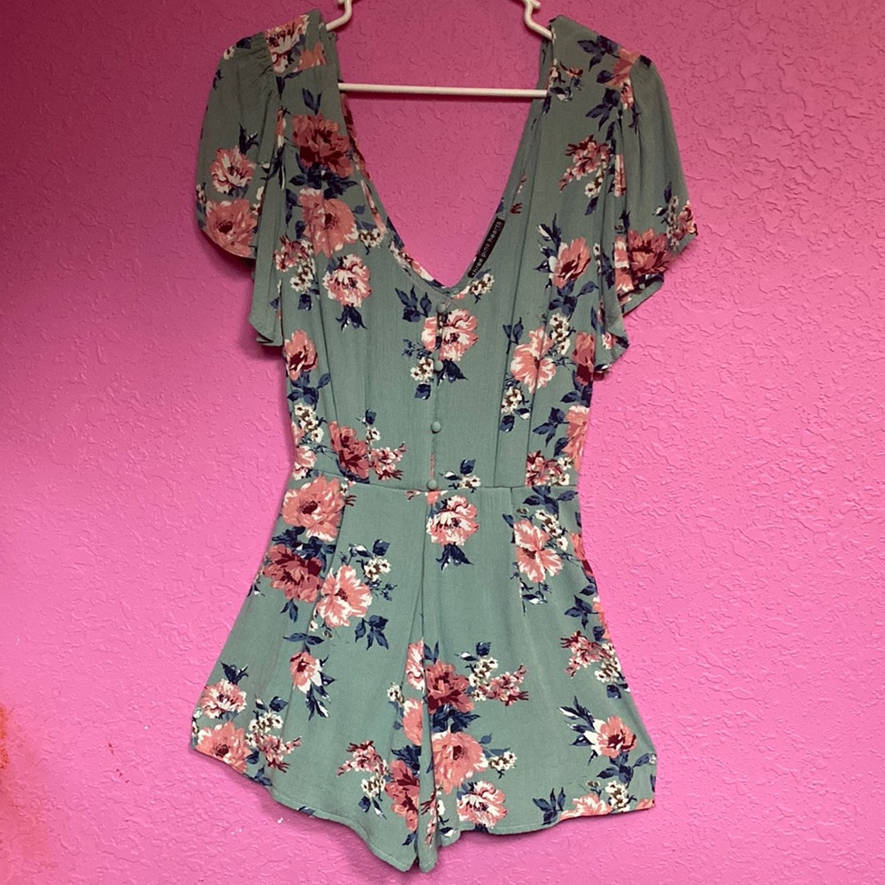 Size S teal romper with pink flowers and blue leaves. Brand three pink hearts.